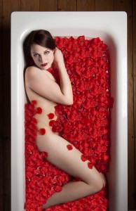 Frau in Badewanne mit Rosenblüten