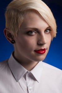 Portrait einer blonden Frau vor blauem Hintergrund im Fotostudio