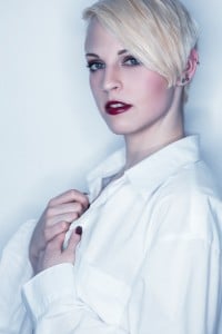 Blonde Frau vor weißem Hintergund im Fotostudio