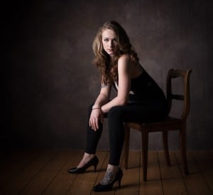 Portrait einer Frau auf einem Stuhl im Fotostudio