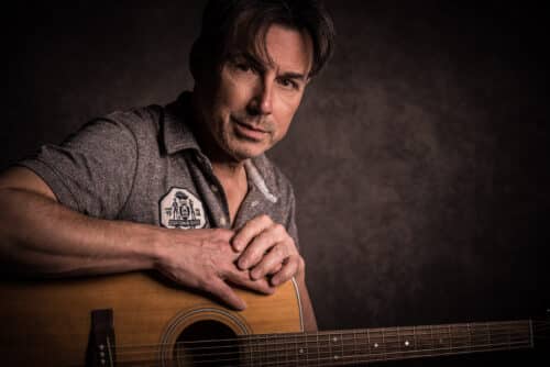 Portrait von Mann mit Gitarre im Studio