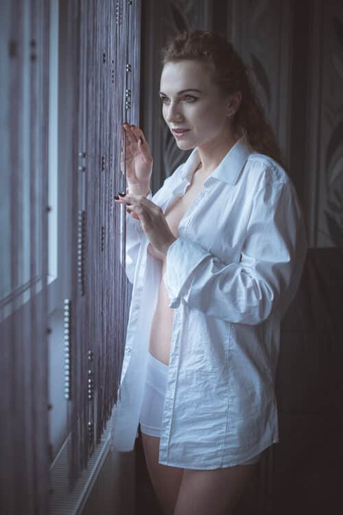 Frau im Hemd an Fenster