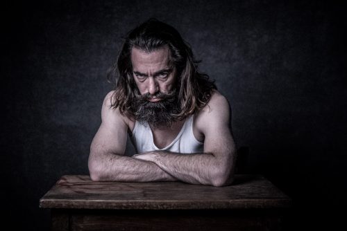 Portrait-Foto von Mann mit Bart am Tisch