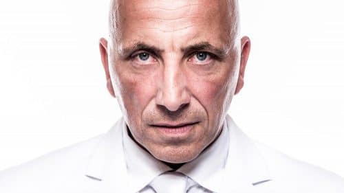 Highkey-Portrait eines Mannes mit Glatze im weißen Anzug vor weißem Hintergrund